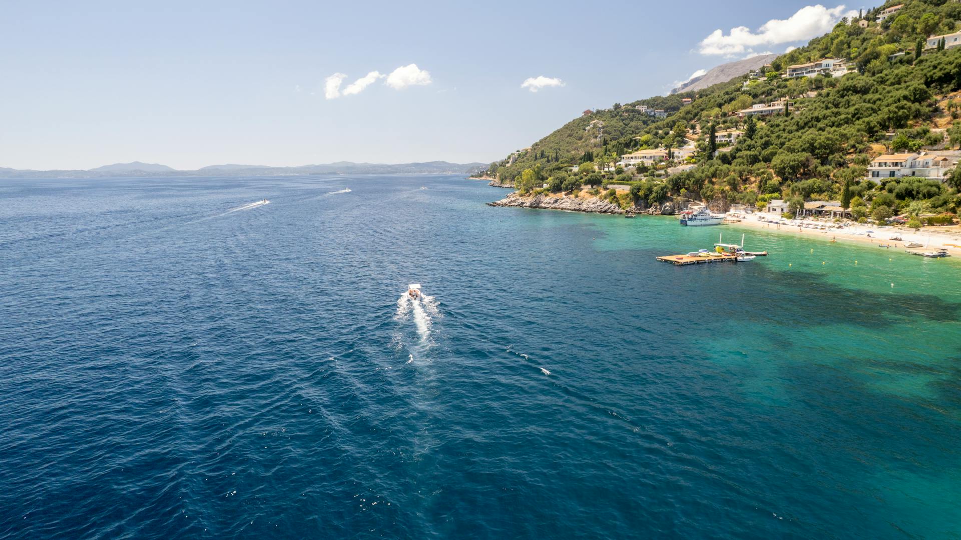 Ionian coastline with villas and boats